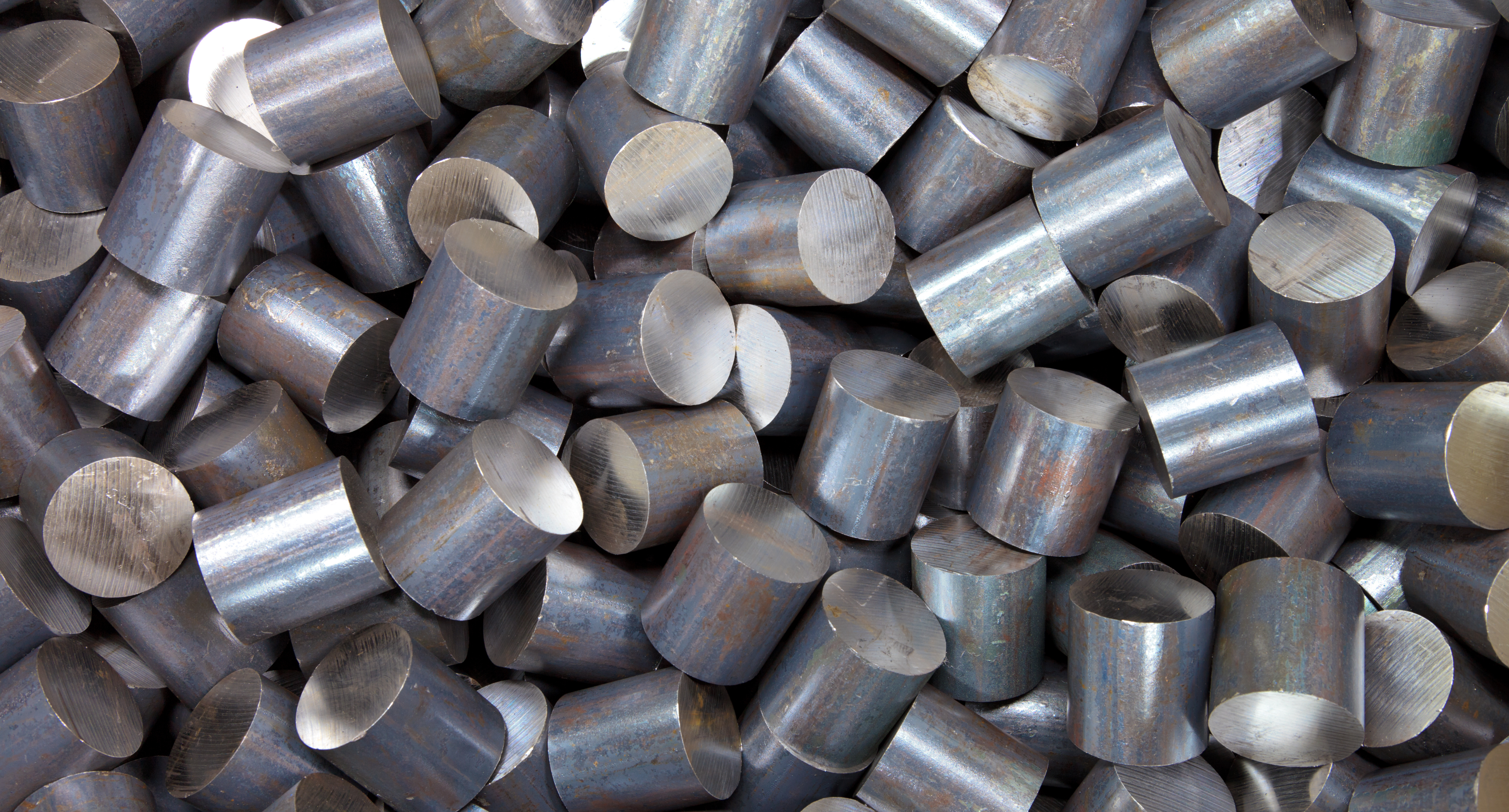 A pile of cylindrical stainles steel raw material, waiting to be processed